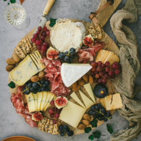 Caterer on booth Board of aged cheeses